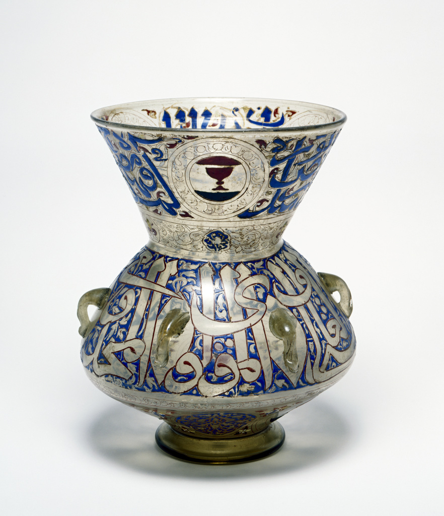 a glass mosque lamp decorated with blue, and red calligraphy and symbols