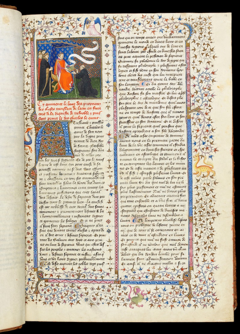 A page of a medieval manuscript with a border decorated with leaves, angels and dragons.