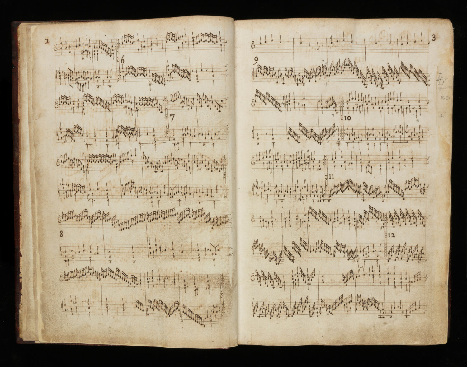 A book of medieval shet music open at two pages tat show a complicated musical score.