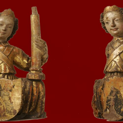 Two small wooden angels, kneeling and facing each other.