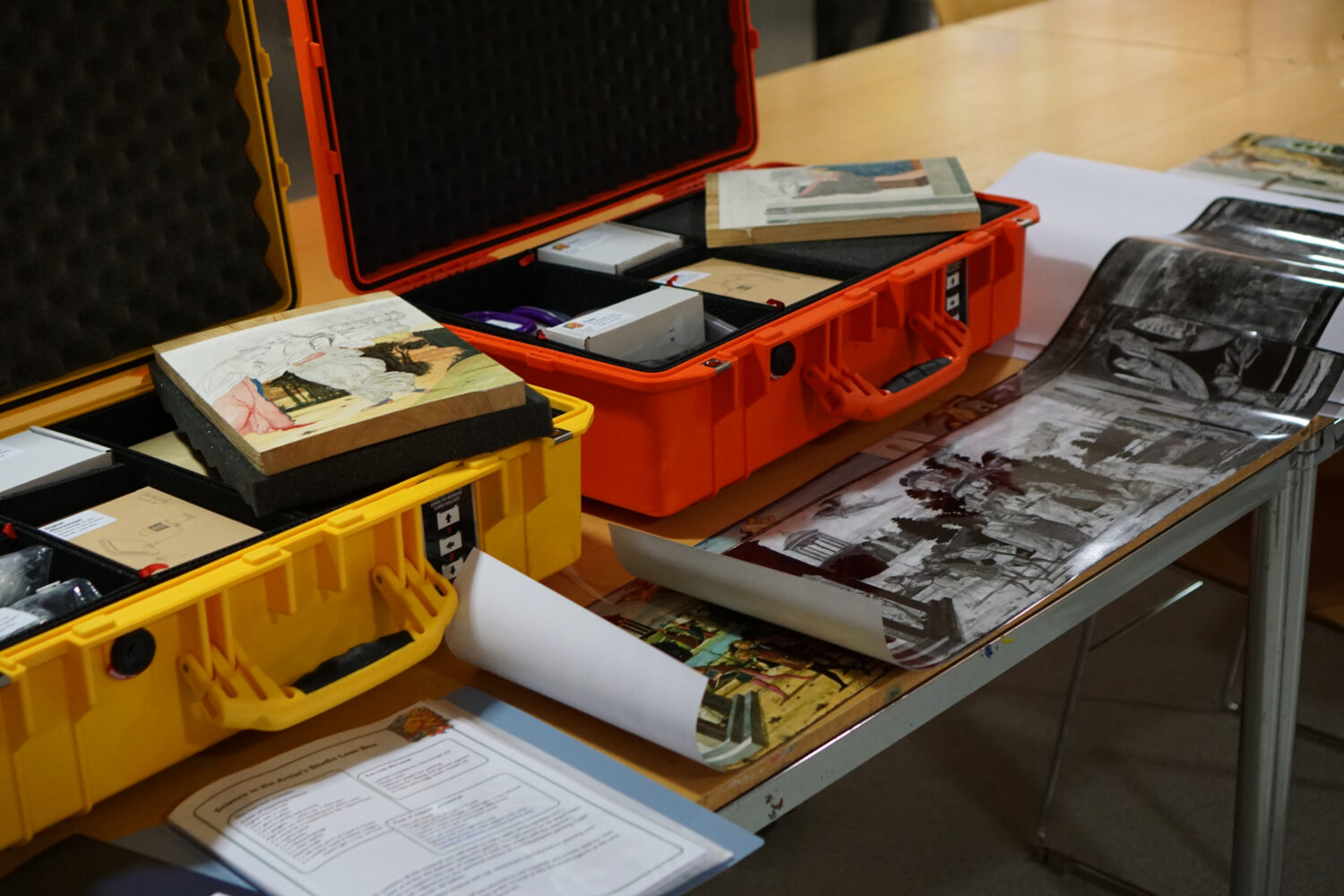 Two plastic suitcases pictured open ad full of images, tools and guidance on science in art.